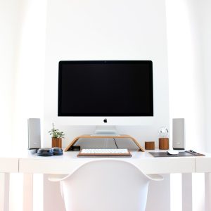 编辑苏叶在显示器前逐项测试鼠标回报率设置，旁边放着记录本与不同版本的无线接收器，环境安静整洁